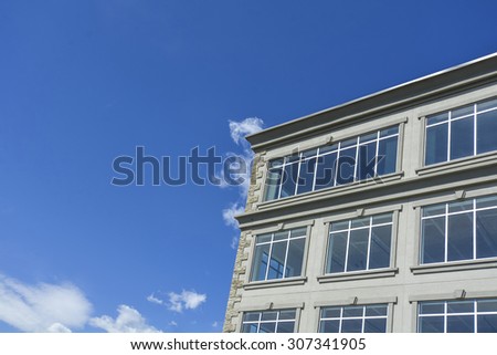 Fragment of the office buildings with modern corporate architecture on blue sky background. Facade with windows.