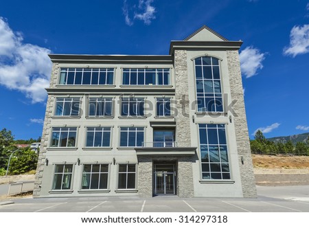 Brand new commercial building with retail and office space available for sale or lease.\
New office building with parking stalls in front and blue sky background awning opening.