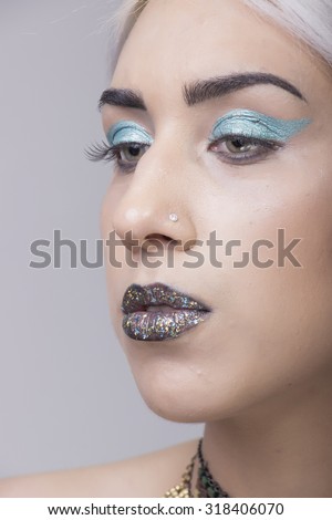 Close up of retouched girl portrait. Flawless skin, eccentric style, shiny lips.