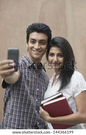 College students taking a picture of themselves with a camera mobile