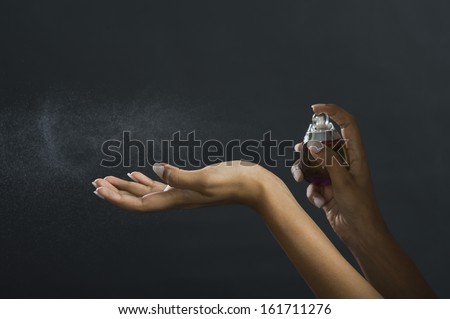 Woman applying perfume on her hand