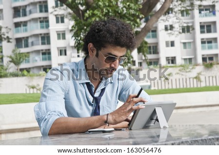 Businessman using a digital tablet in a garden