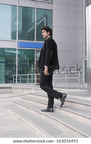 Businessman moving down on steps