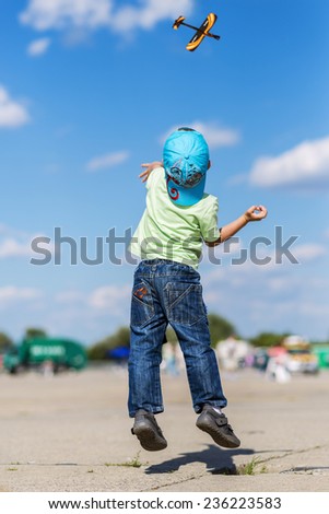 Little boy jumping to launch an airplane toy model