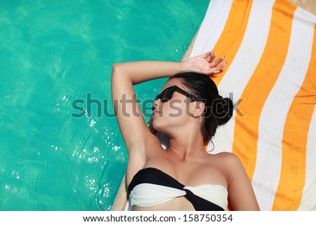 Women on poolside.women in bikini lying on the poolside