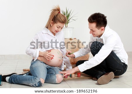 pregnant woman and a man painted on belly