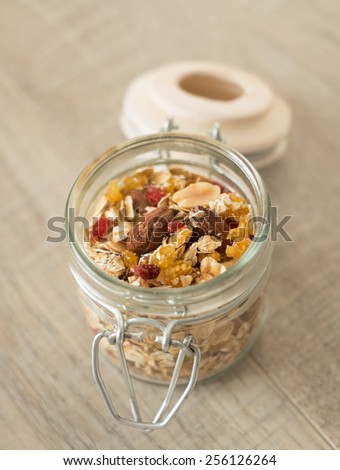Homemade granola with oats, toasted nuts, dried cherry and honey in a jar, selective focus