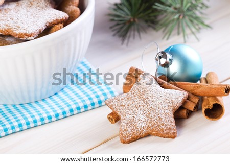 Christmas cookies and cinnamon sticks on wooden background