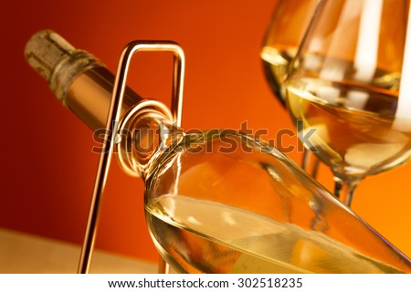 White wine bottle on a metal wine rack and two glasses with white wine