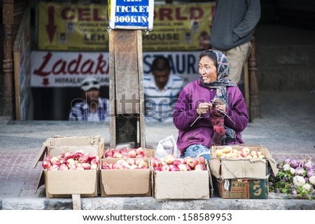 LEH, INDIA - OCTOBER 01: Market woman beside street selling vegetable and food in Leh, India. October 01, 2013
