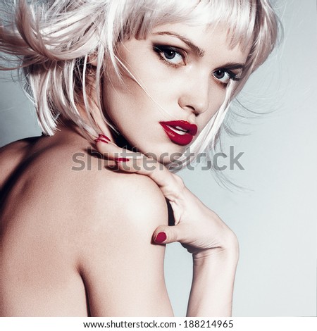 Portrait of a beautiful blonde girl in studio with hair flying, close up