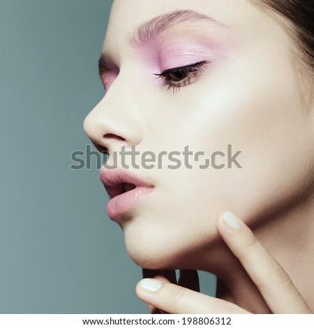 Portrait of a beautiful girl face in profile against a blue background