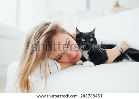 Portrait of a beautiful girl with a cat in the interior