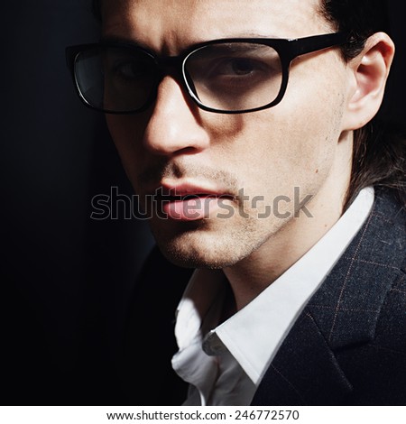 Portrait of a handsome man in the studio with glasses, closeup