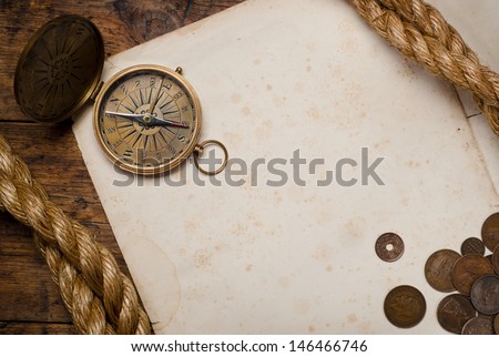 old compass, old coins and rope on vintage map  old compass, old coins and rope on vintage  background