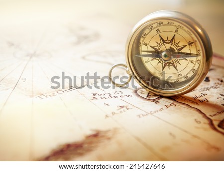 Old compass on vintage map. Retro stale.