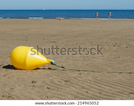 Sea buoy anchored in the sand when the tide is out
