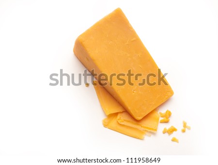 A Block Cheddar Cheese On Top Of Some Cheese Shavings And Crumbs On A ...