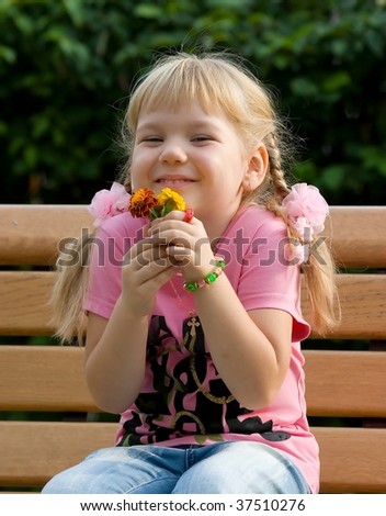 Cute little girl with flowers, smiling.