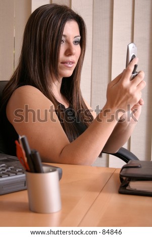 Woman at desk communicating cellphone