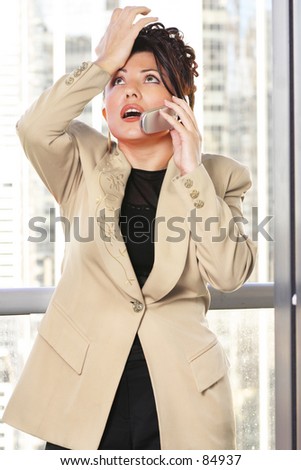 Businesswoman makes a gestuer while on the phone. -- eg: annoyed, frustrated, forgetful, mistake