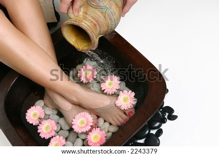 Beautifying feet.  Warm water is poured into a luxurious footbath.  Space for copy