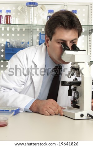 Scientist, biologist, geneticist,  researcher  or healthcare worker studying an object under the microscope