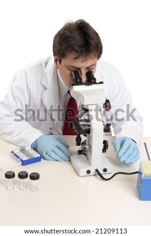 a male scientist, medical worker  or researcher studies a substance on a slide under the microscope.