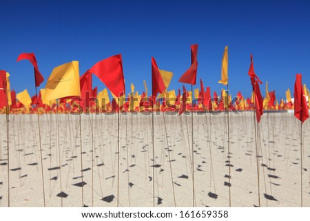 BONDI BEACH, AUSTRALIA - OCTOBER 30, 2013: Sculpture By The Sea, Bondi 2013. Annual public event  Sculpture titled \'Red Centre\' by Carl Billingsley (USA).  Medium red and yellow survey flags