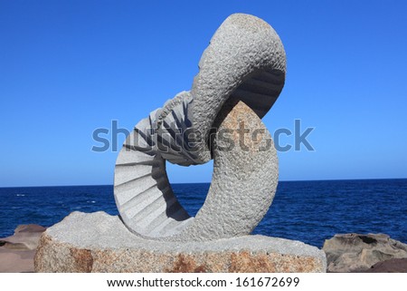 BONDI BEACH, AUSTRALIA - OCTOBER 30, 2013: Sculpture By The Sea, Bondi 2013. Annual event that showcases artists from around the world  Sculpture titled \'2 rings\' by Keizo Ushio, medium, granite
