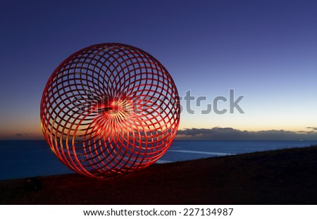 BONDI, AUSTRALIA -  OCTOBER 29, 2014; Sculpture by the Sea Annual Event 2014.  Sculpture titled Sisyphus by George Andric, SA.  Lightpainted with a torch for a red glow.  Materials, stainless steel.