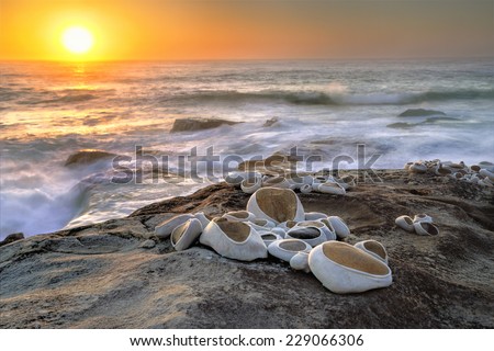 BONDI, AUSTRALIA - OCTOBER 30, 2014; Sculpture by the Sea  titled to take care of by artist Hannah Streefkerk, Sweden.  Stones covered in bandagesBondi with sunrise backdrop  - protecting nature