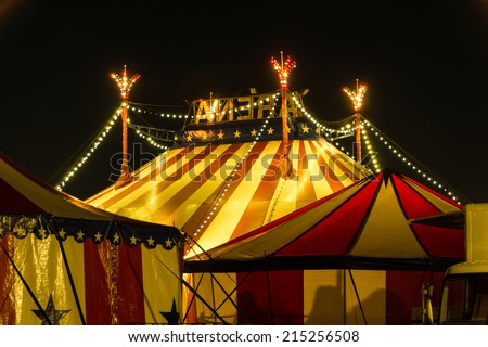 An illuminated big top at night with the nigh sky at background