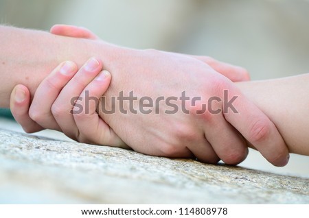 clasped hand for help on a granite rock