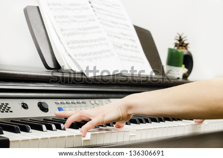 Close up of the hands of a young woman playing piano