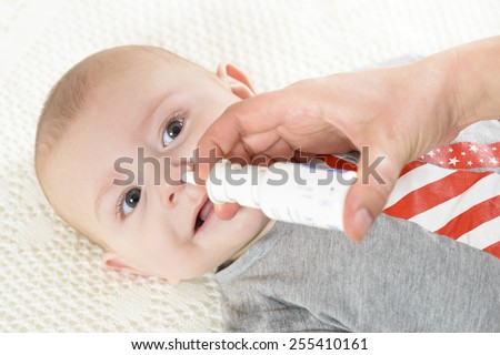 Woman using nasal spray for baby
