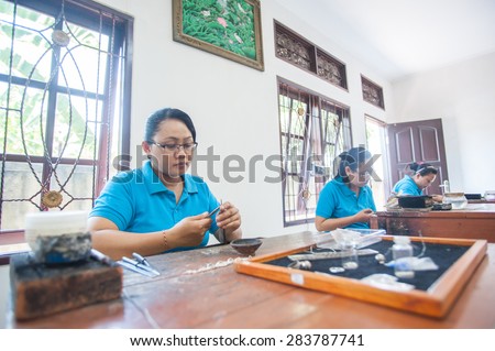 BALI, INDONESIA - NOVEMBER 3RD 2014 : Balinese women are working on a silverware and sell it to the tourist.