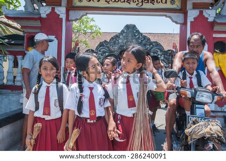 BALI, INDONESIA - NOVEMBER 3RD 2014 : Balinese kids in school uniform just finish and out from school. Parents pick them up with motorcycle.