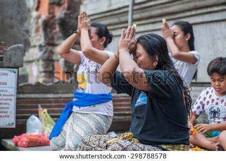 BALI, INDONESIA - NOVEMBER 3RD 2014 :  Balinese people pray before they cleanse themselves in Holy Spring at Tirtha Empul Bali, Indonesia.