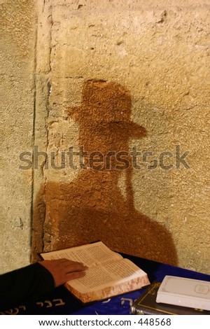 The shadow of a praying man on the wailing wall.