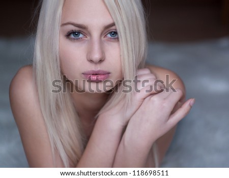 portrait of a beautiful blonde with perfect clean skin, lying down
