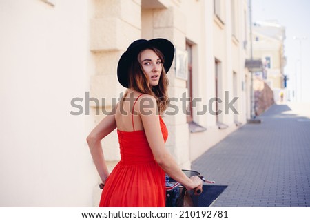 Beautiful woman in red dress with bike