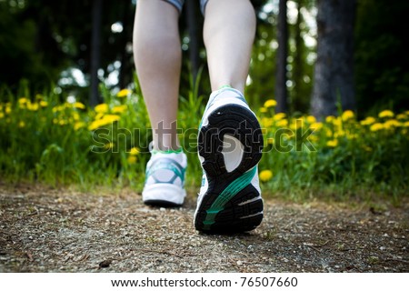 Woman walking cross country and trail in spring forest