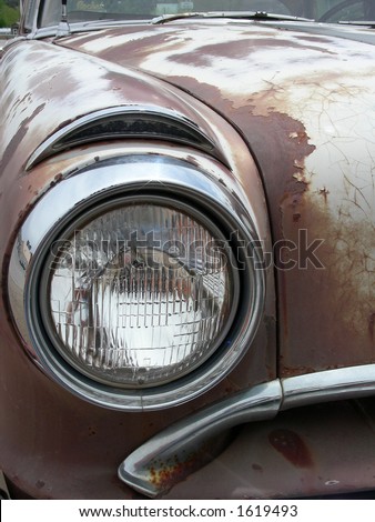 Rusted hood and head lamp on vintage automobile