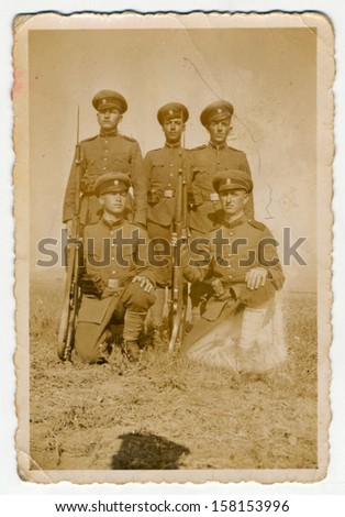 CENTRAL BULGARIA, BULGARIA - CIRCA 1950: Group of soldiers with rifles posing in the field - Note: slight blurriness, better at smaller sizes - circa 1950