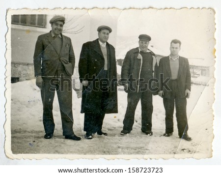 CENTRAL BULGARIA, BULGARIA - CIRCA 1955: the area Plovdiv - Four men posing in winter time - Note: slight blurriness, better at smaller sizes - circa 1955