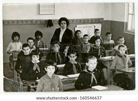 CENTRAL BULGARIA, BULGARIA - CIRCA 1950 - Classmates in the classroom with their teacher circa 1950