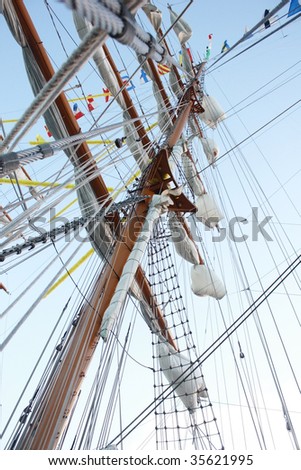 Mast with white sails and flags of the world