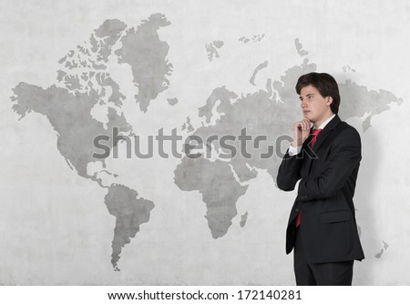 Thinking businessman in front of the world map