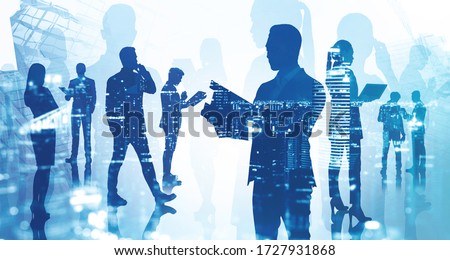 Silhouette of businessman with clipboard and his teammates working together in blurry city with double exposure of night cityscape. Concept of leadership and teamwork. Toned image